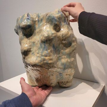 Hands hold a sculpture by Sonya Bogdanova
