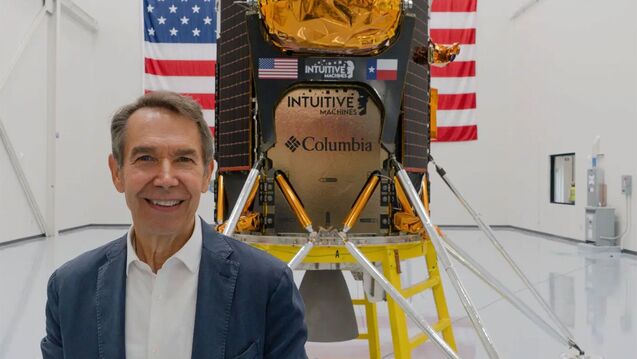 Jeff Koons holds his artwork Moon Phases in front of a spacecraft