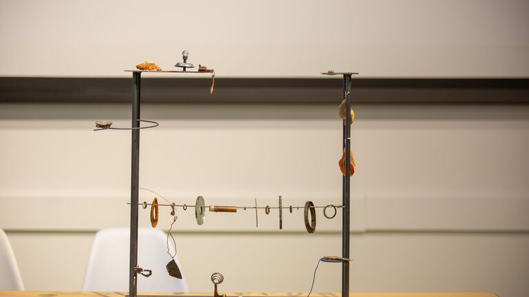 An image of various found, metal objects strung up on a wire. 