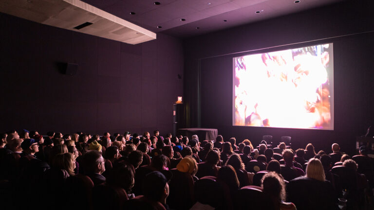 Audience in theater viewing a film