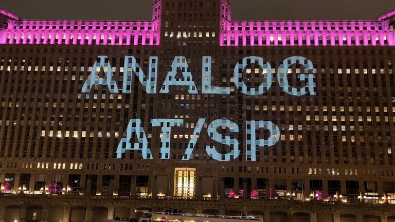 A photo of Chicago's Merchandise Mart with the words "Analog AT/SP" displayed in lights across the building