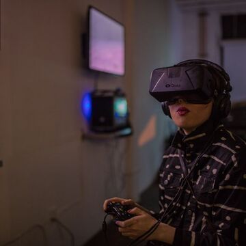 A person wearing a VR headset using a controller. 