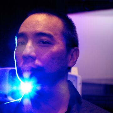 An image of Apichatpong Weerasethakul standing in front of a projector. 