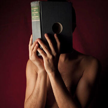 A person with a book in their face, with an eyehole cut out