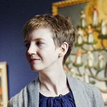 Annie Bourneuf has a pixie haircut and wears a grey sweater over a blue blouse.