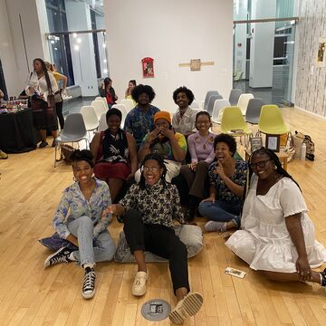 Group photo of COBRA members sitting together in SITE gallery space for exhibition program