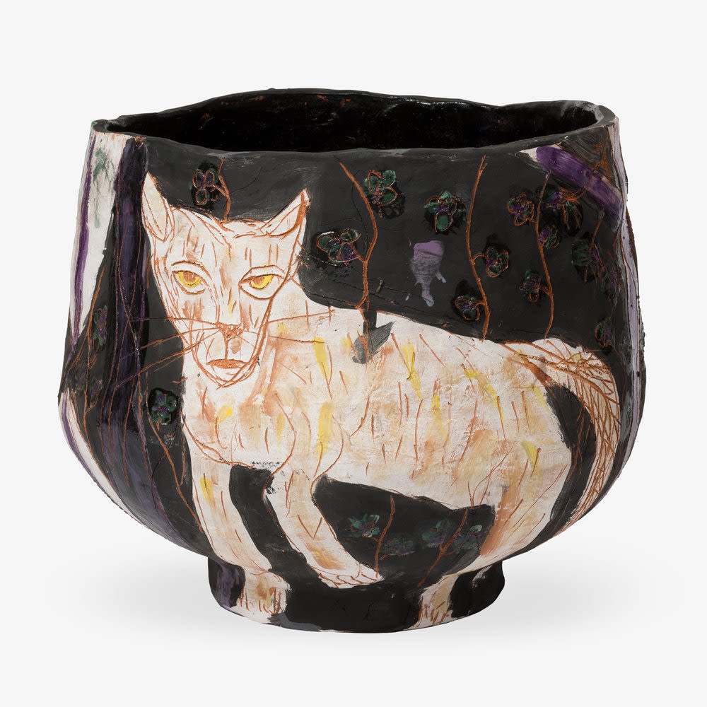 A dark ceramic artwork with a cat