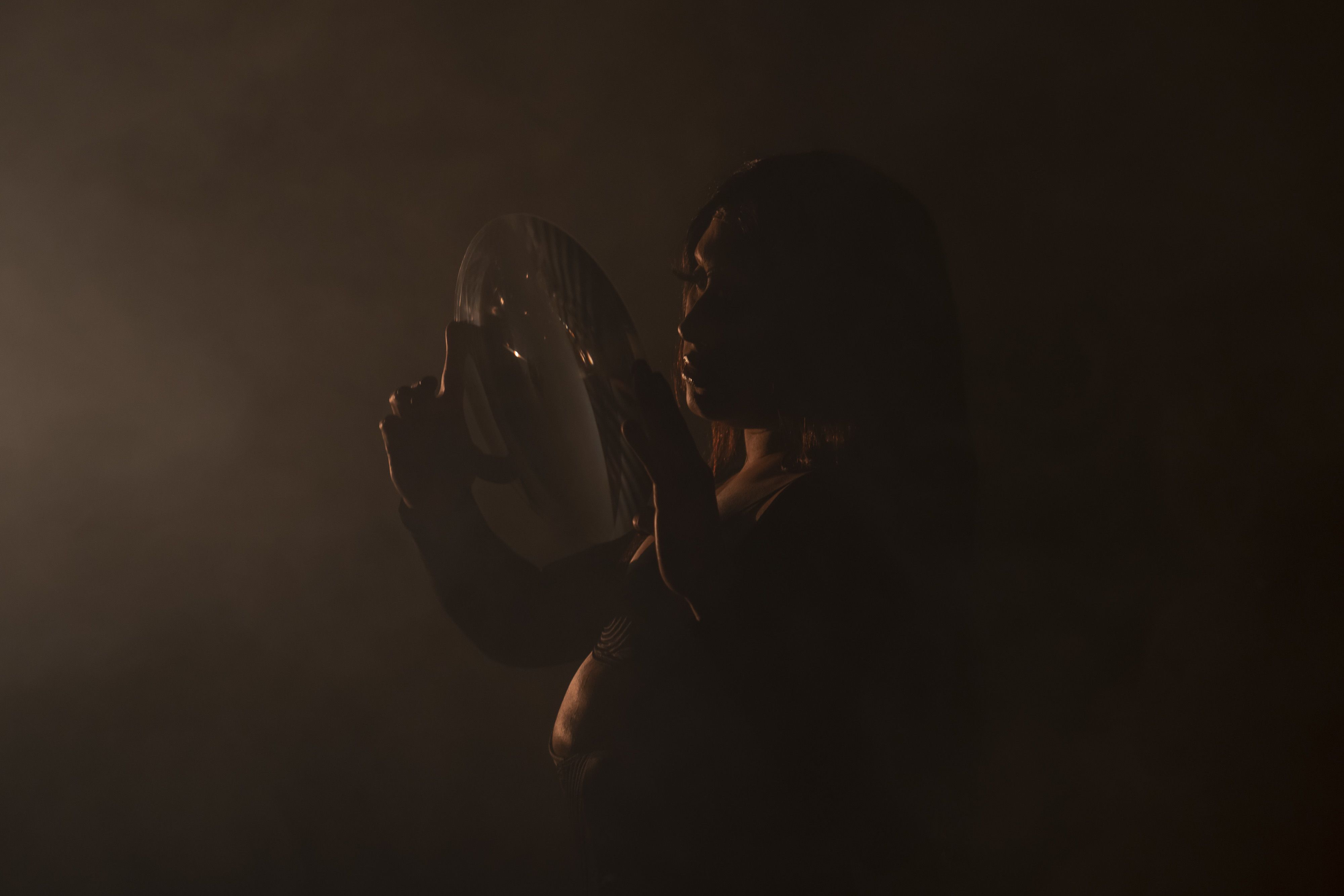 A dimly lit drag queen mid-performance.
