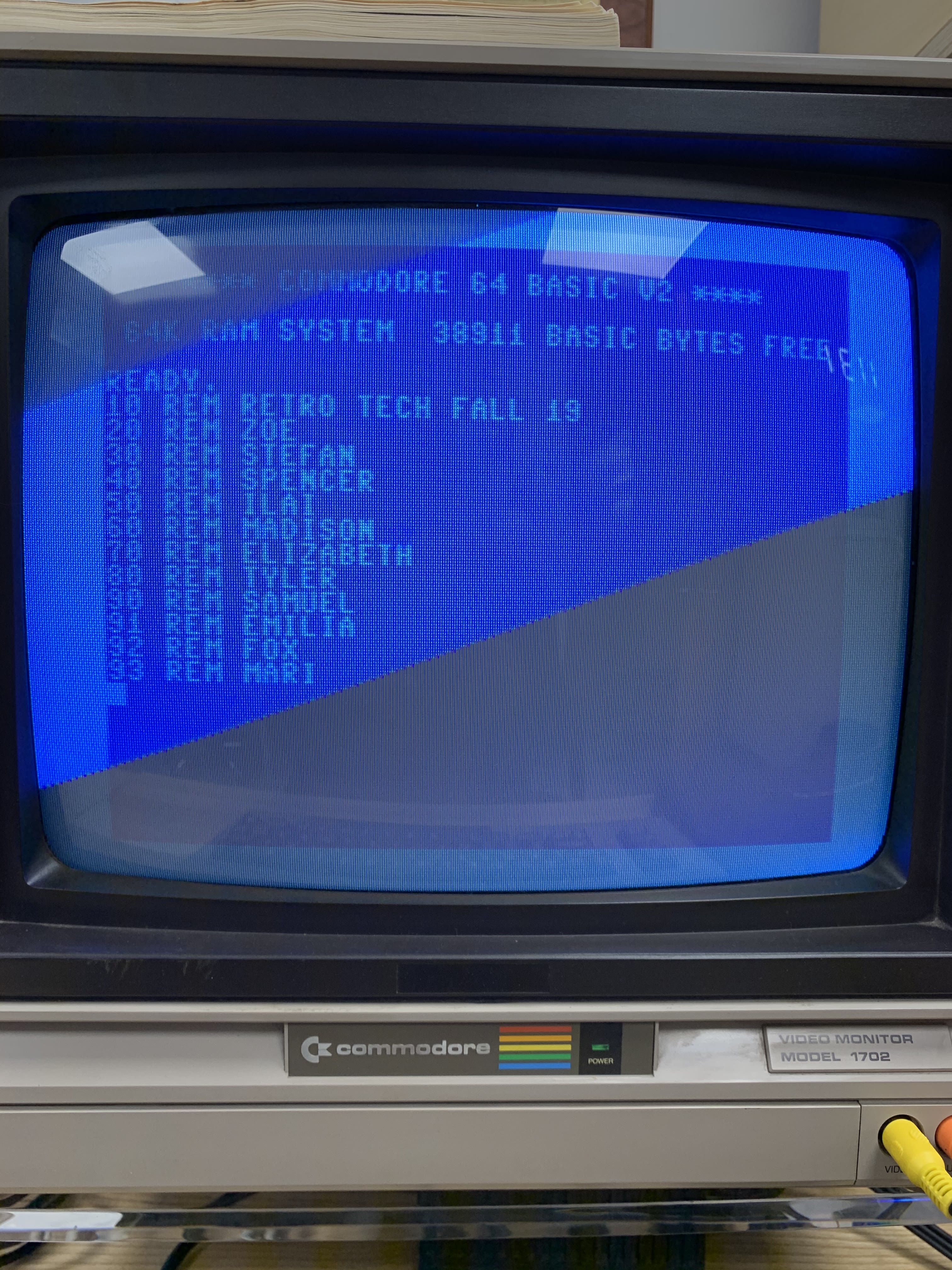 A close-up of an old, bright blue computer screen with names written in blocky text