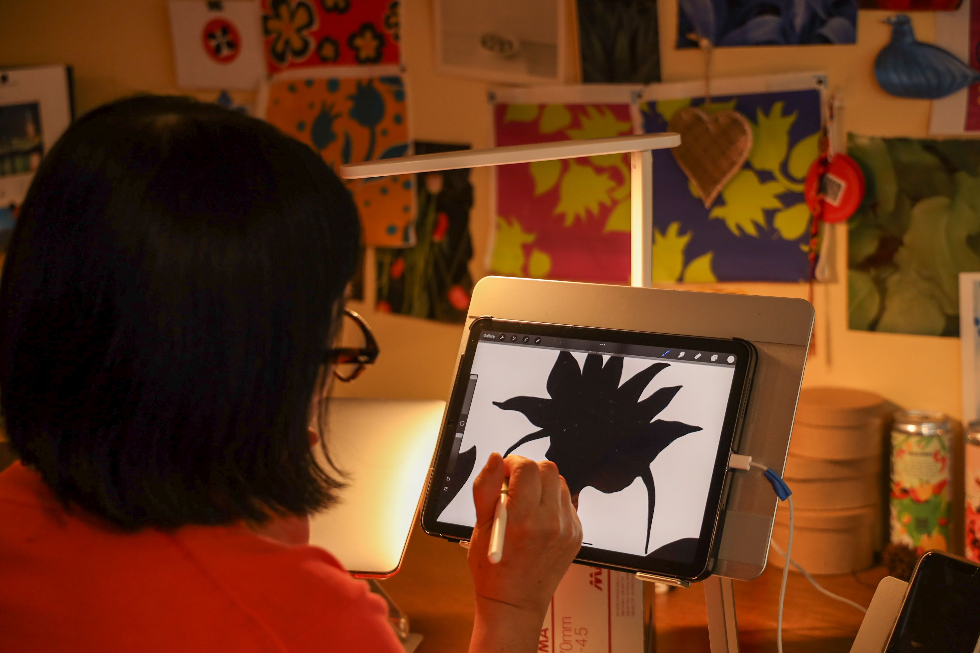 An artist draws a flower on a drawing pad