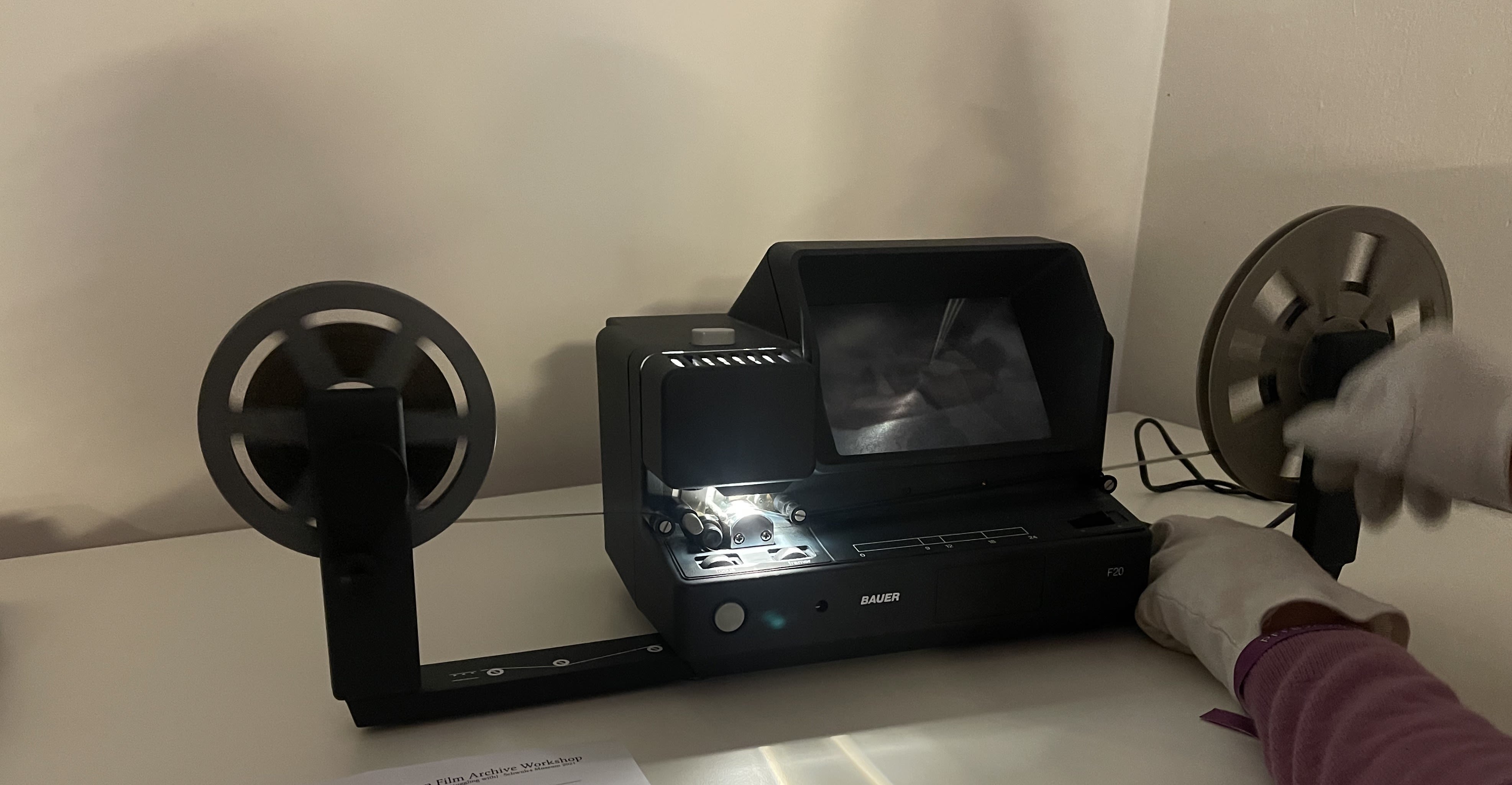 Hands run film through a projector