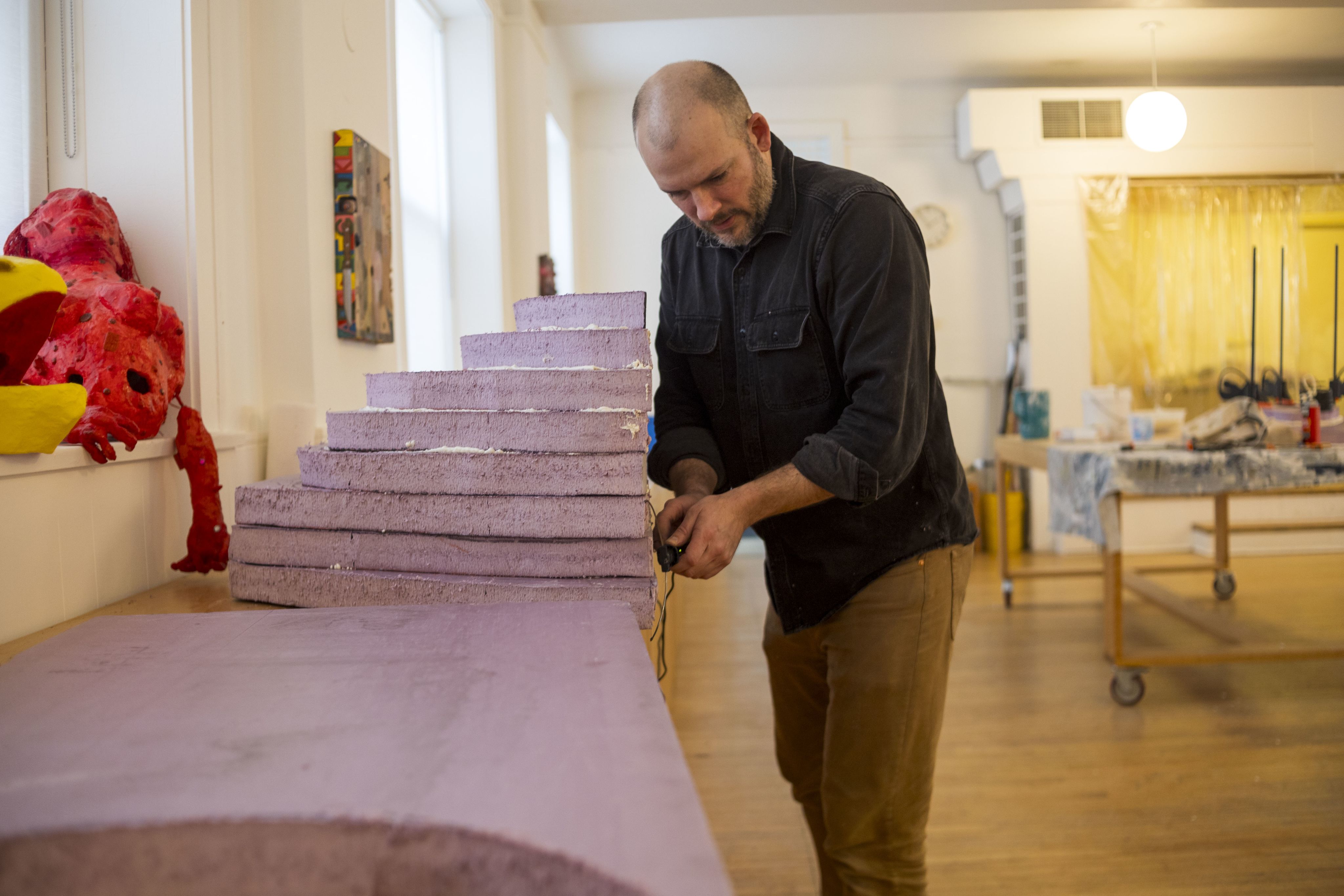 A man standing next to a lilac staircase installation