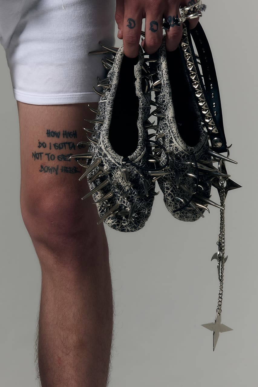 A pair of ballet flats covered in metal spikes and chains