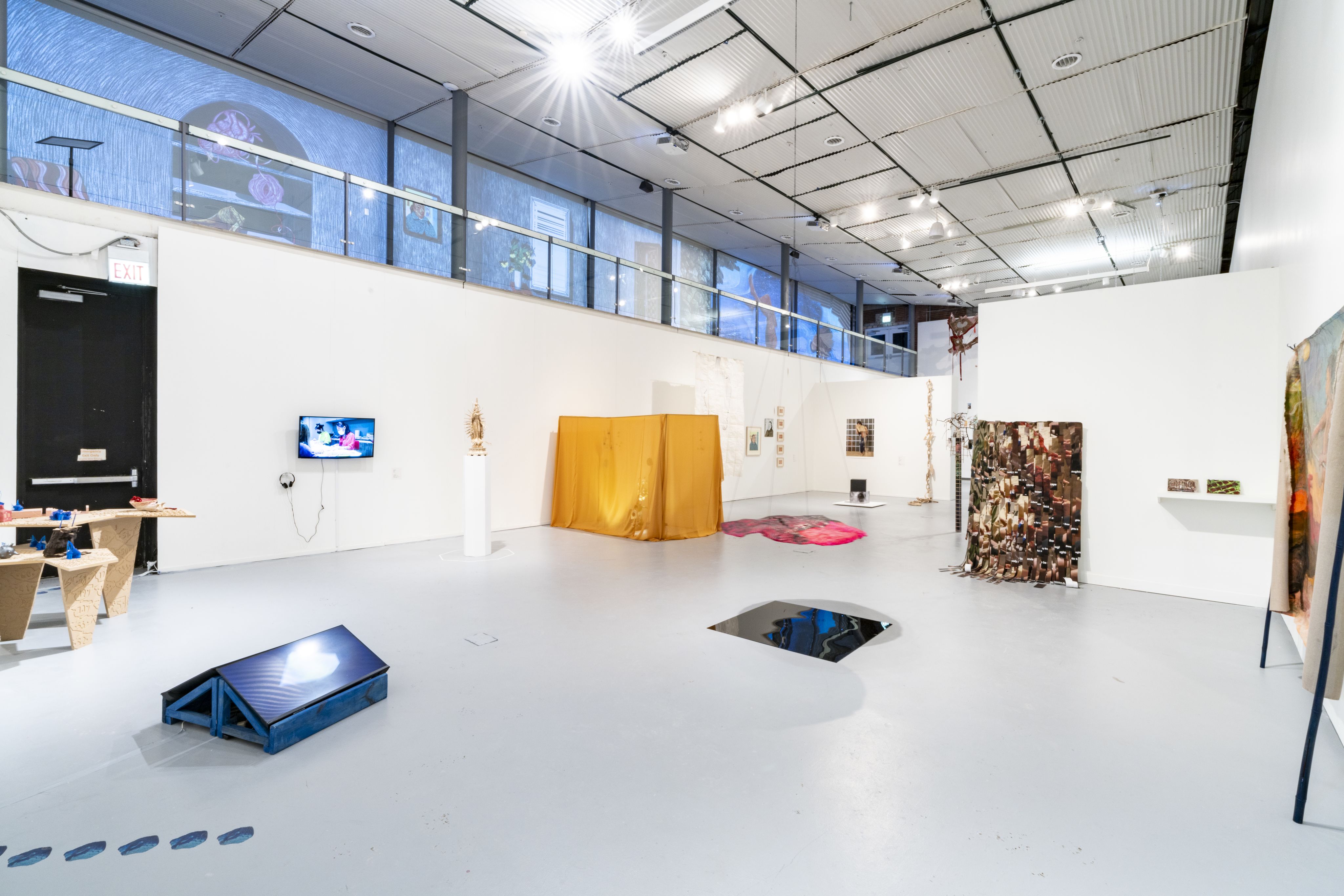 An installation view of Ground Floor Exhibition spread out in a white museum room