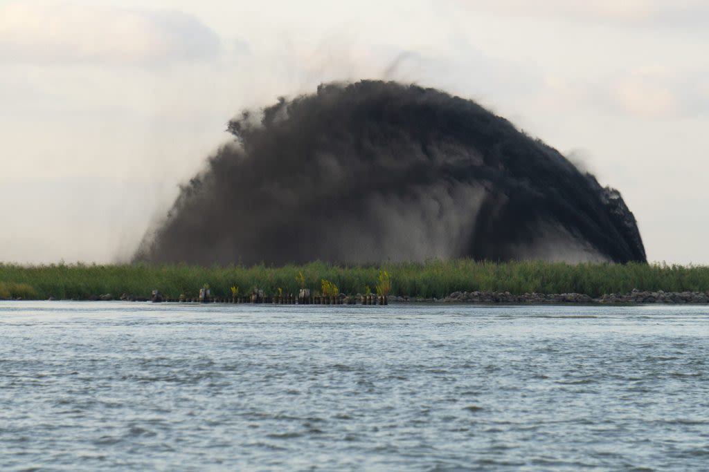 A photo of a body of water with a large, ominous cloud at the shoreline