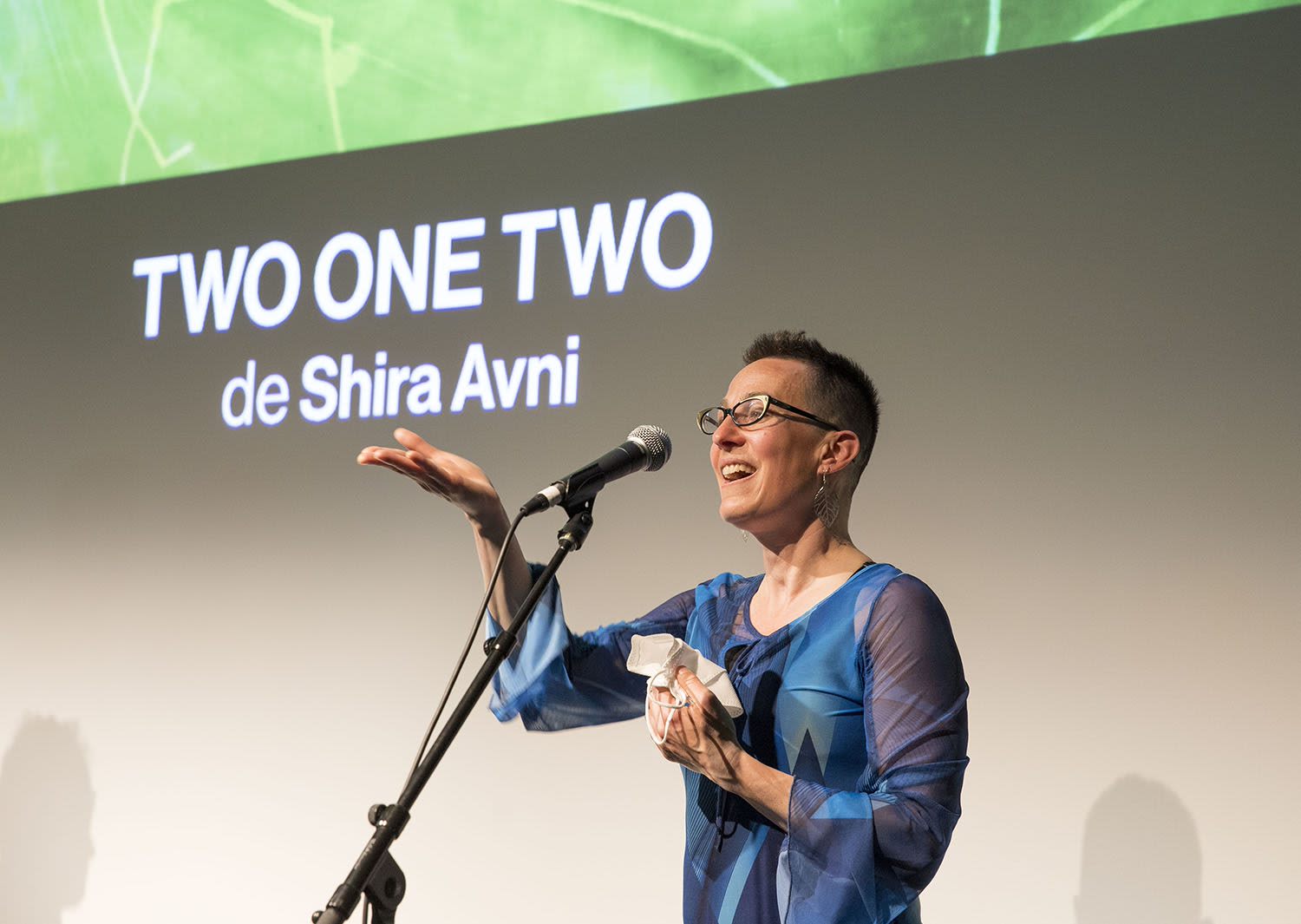 Shira Avni stands at a mic