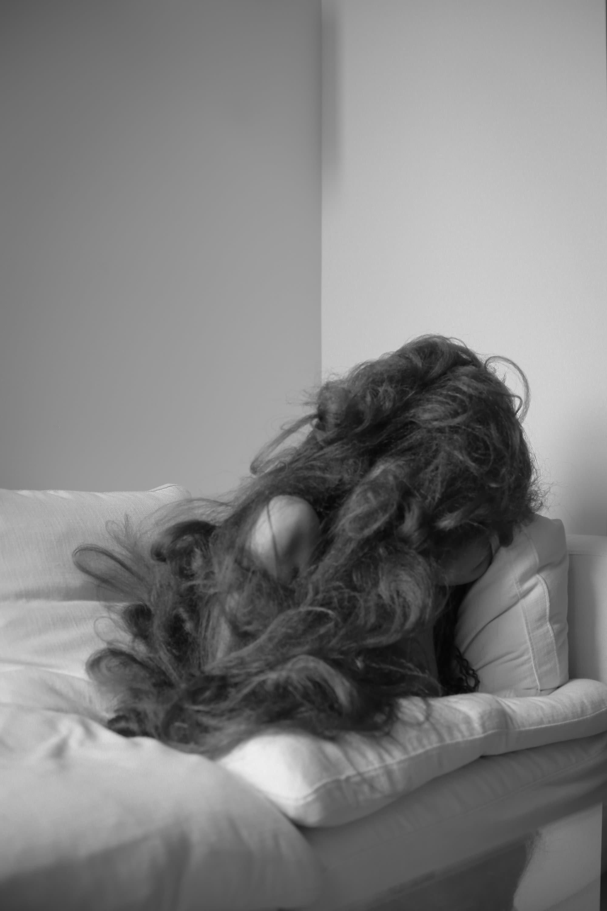 A person sitting on a couch tangled in a large amount of hair