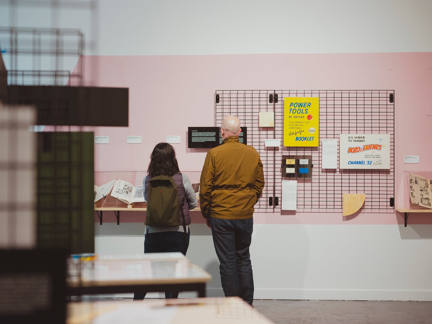 Two people looking at artwork at Letters Beyond Form: Chicago Types