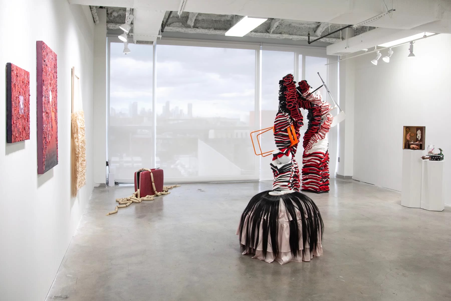 An installation view with several paintings and sculptures