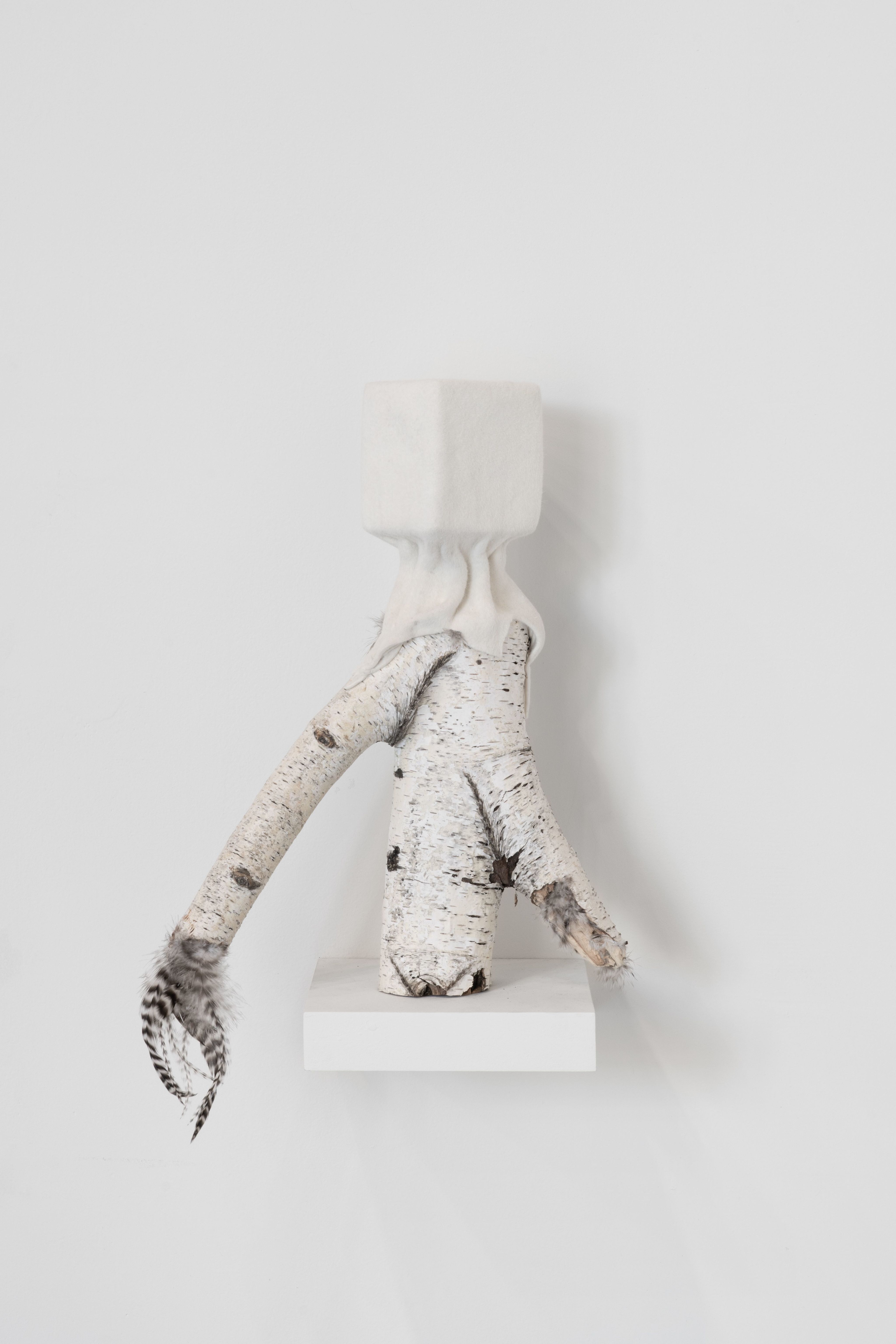 A sculpture with wood and feathers