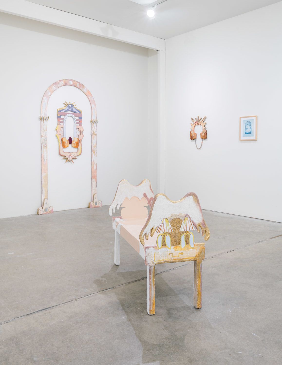 An installation view of six saturated, colored photos on a white gallery wall