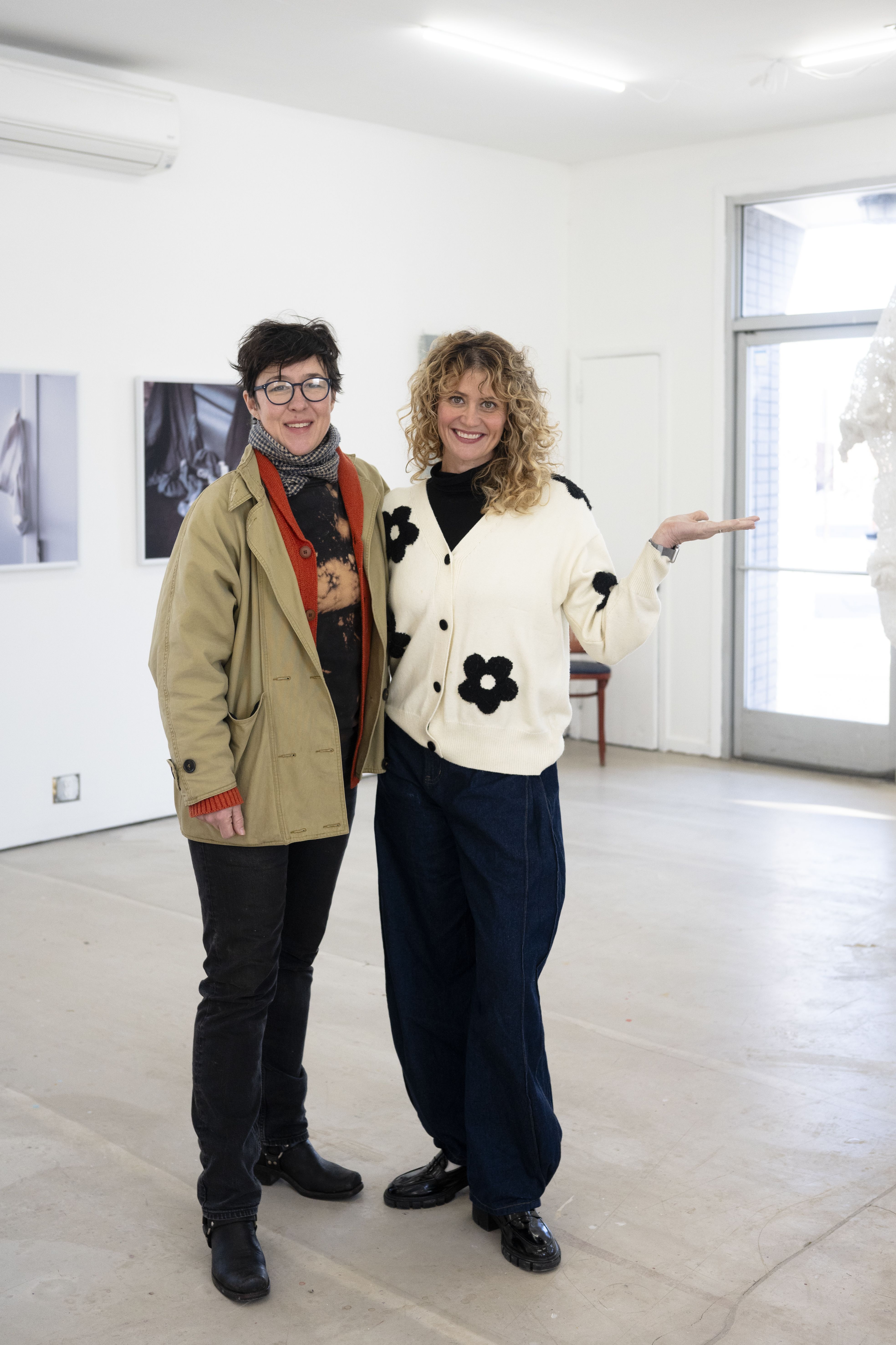 Two women stand in a modern gallery space