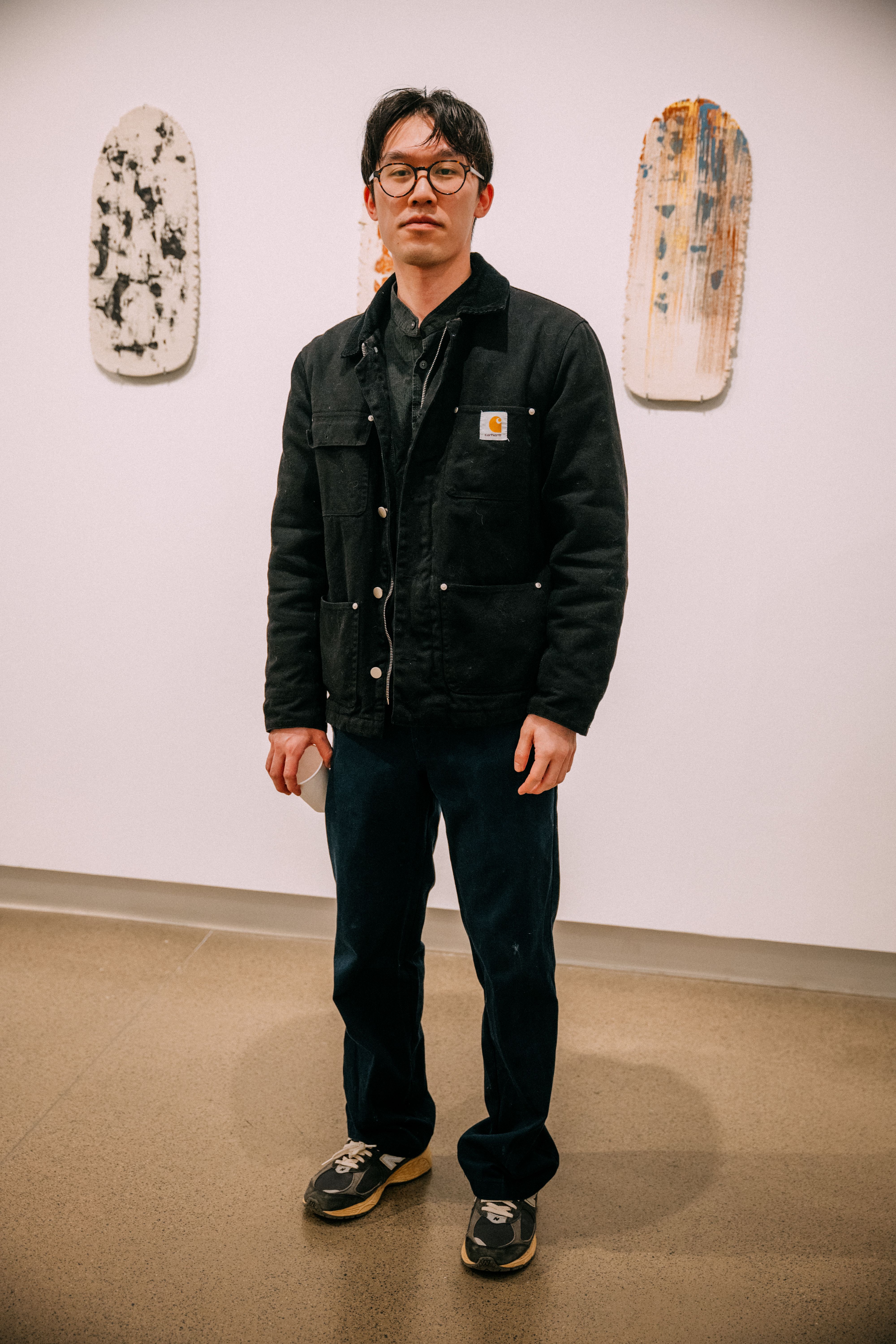 A student poses in a black Carhartt jacker