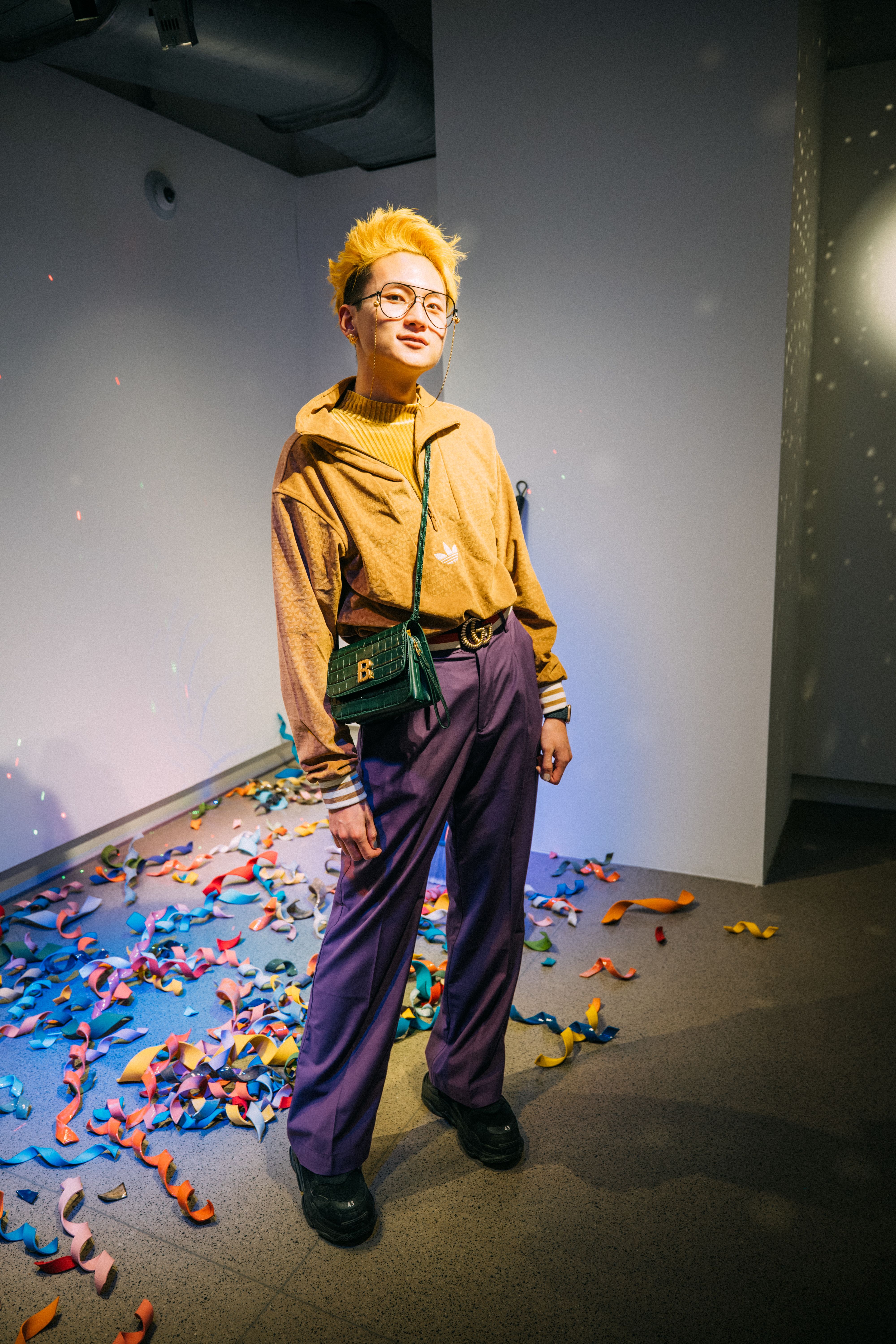 A student poses in front of colorful curls of confetti.