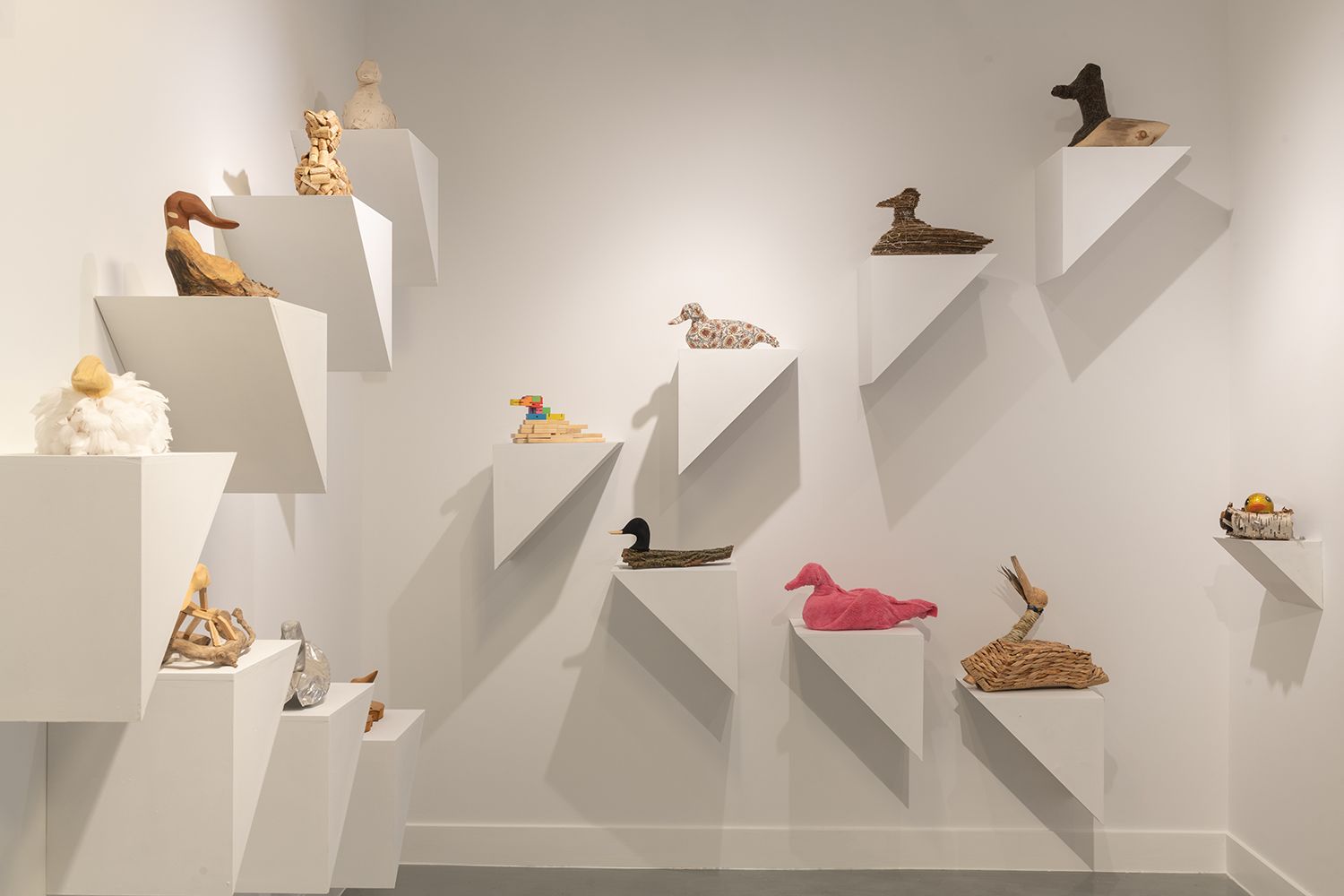 Sculptures of birds mounted on gallery walls