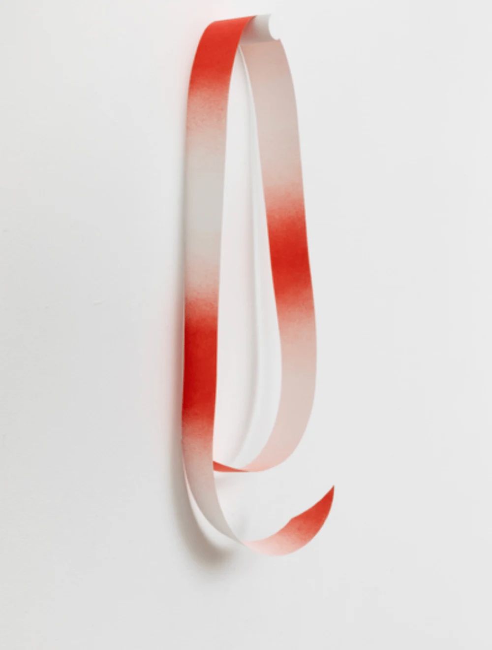 A red and white sash hanging from a wall