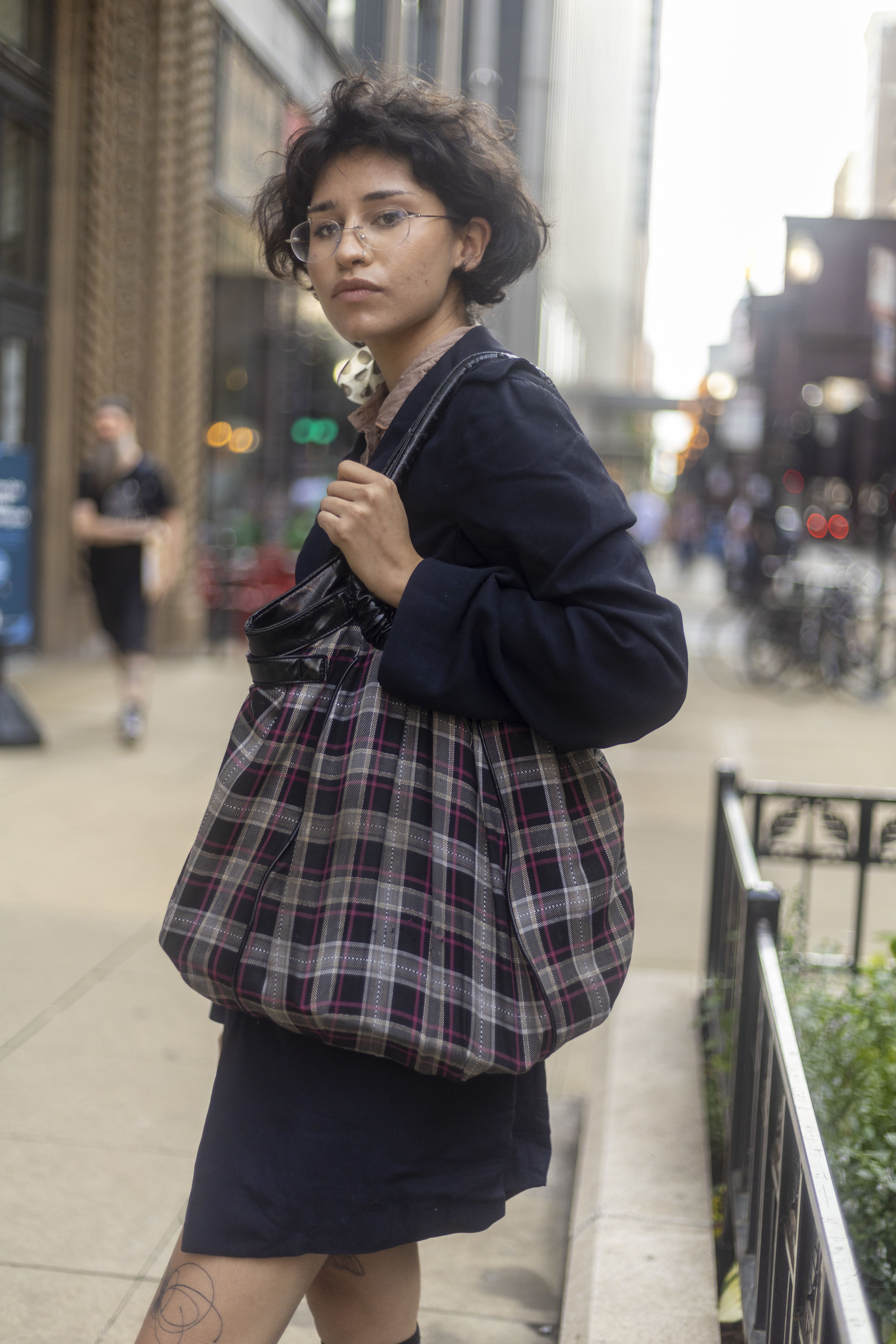A student with a large tartan tote bag