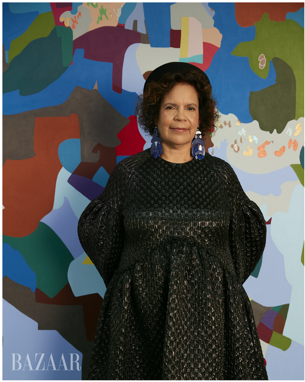 A shot from Harper's Bazaar of Alvarez standing in front of her bright abstract painting.