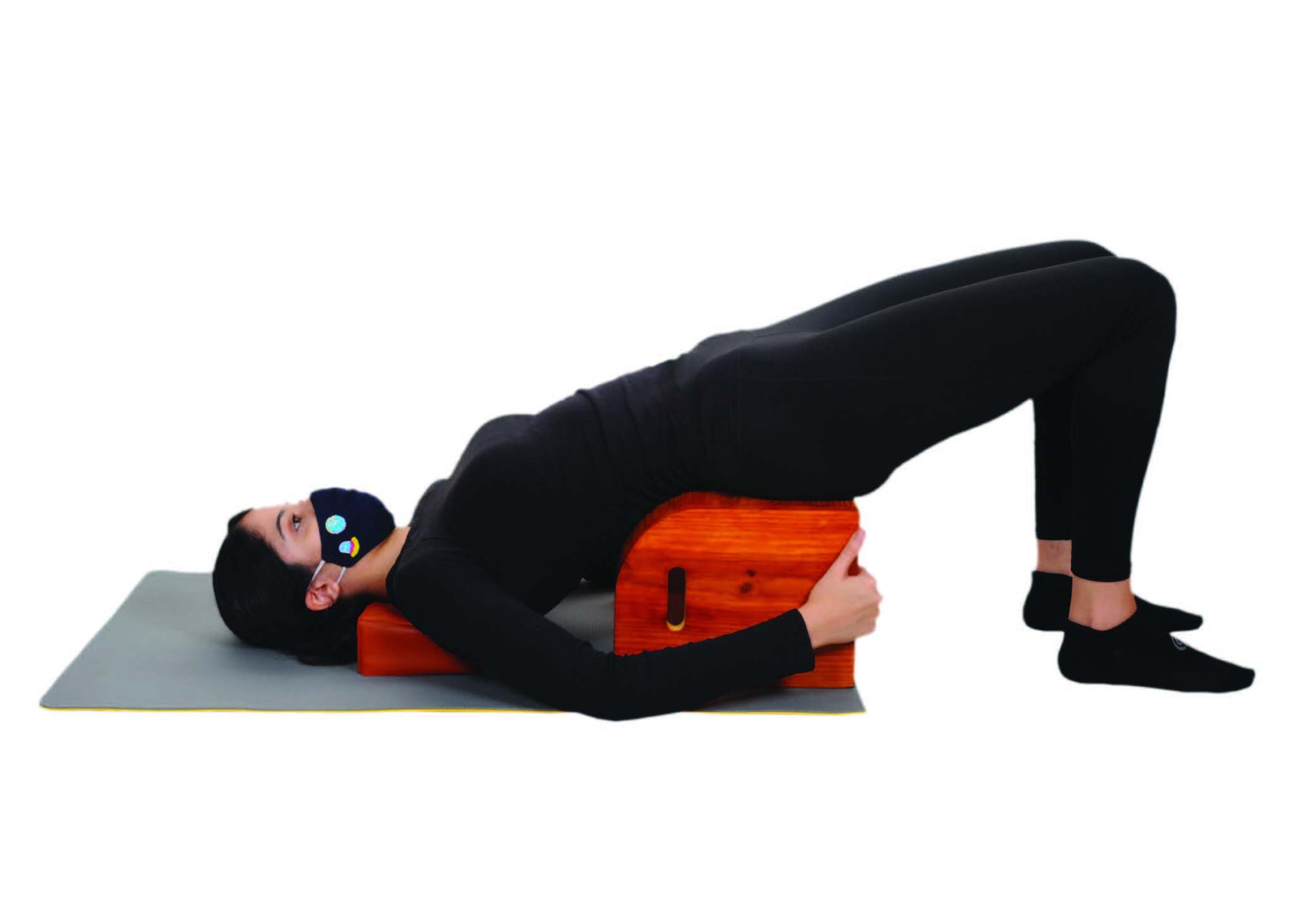 A woman in all black reclines on an orange object