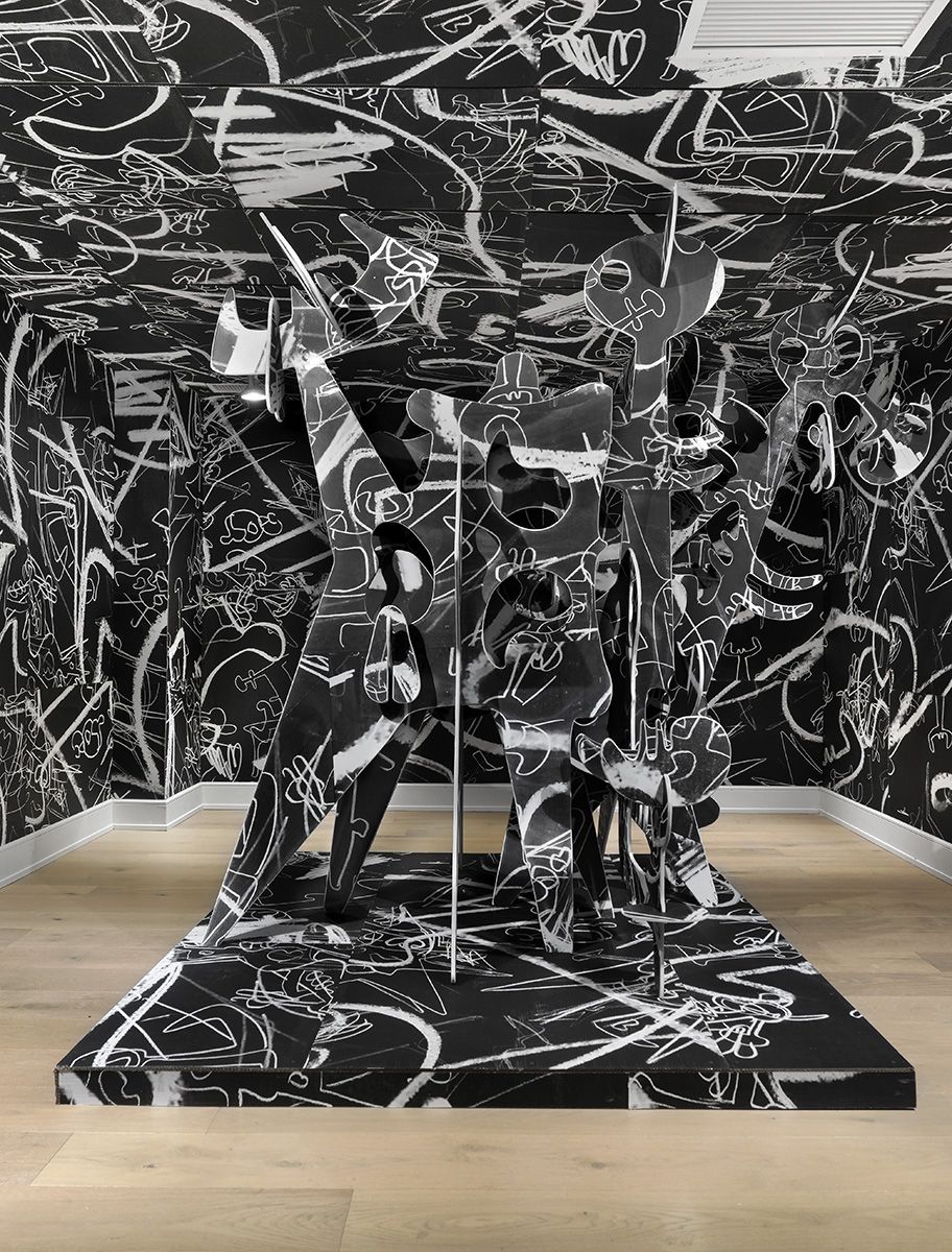 A sculpture in a gallery space with scribbled walls