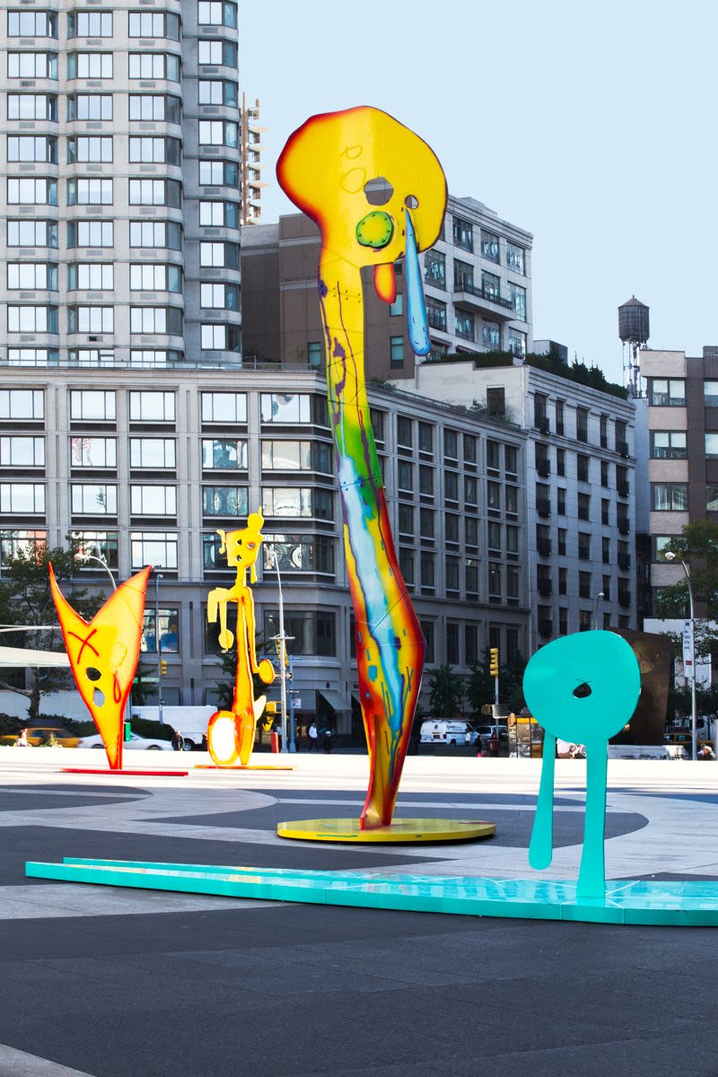 Four colorful abstract sculptures in a city