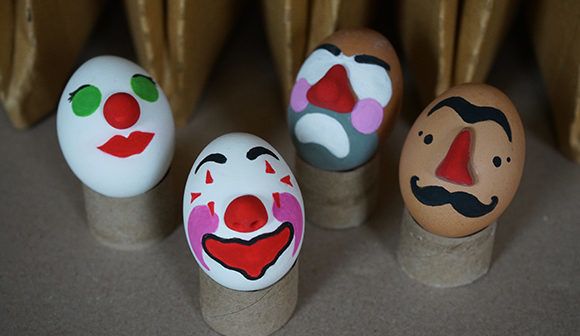 Four eggs with colorfully painted faces.
