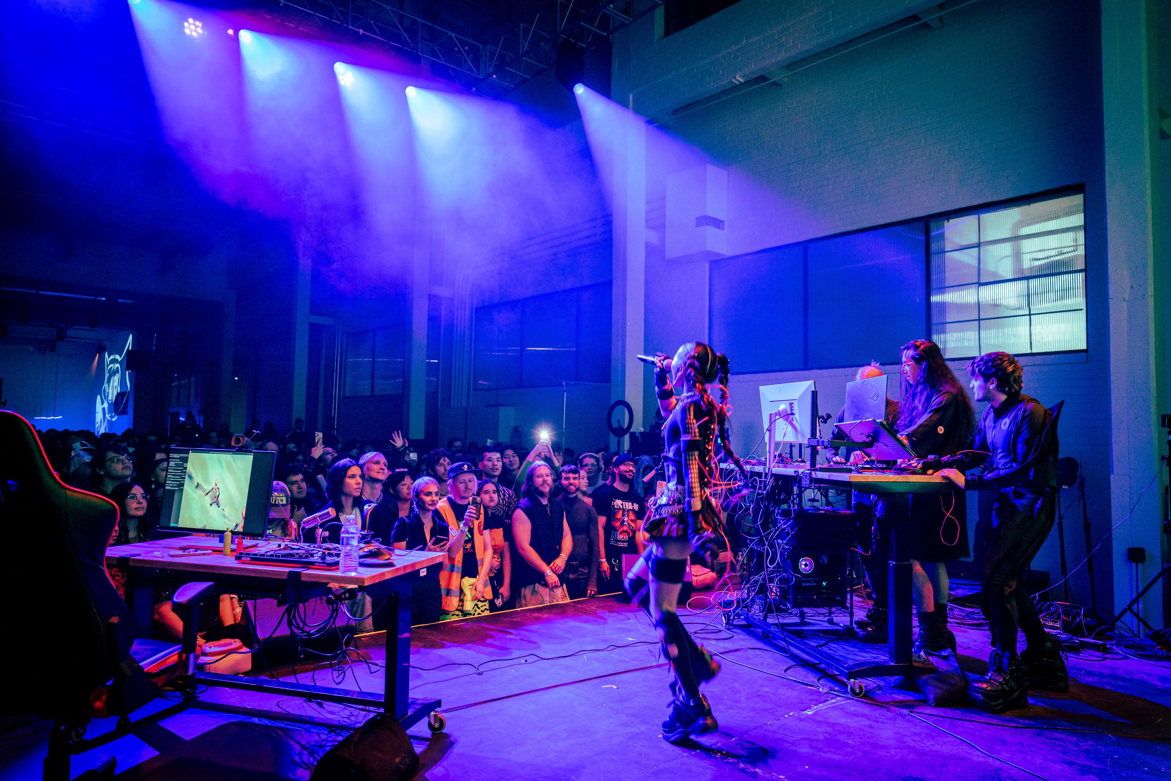 An artist performs on a purple-lit stage