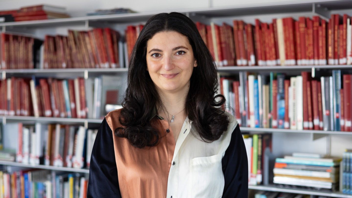 A headshot of a woman against a bookshelf