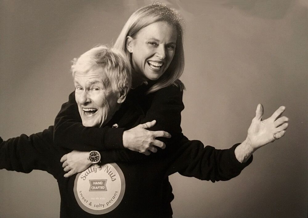 Two women in black posing for a photo