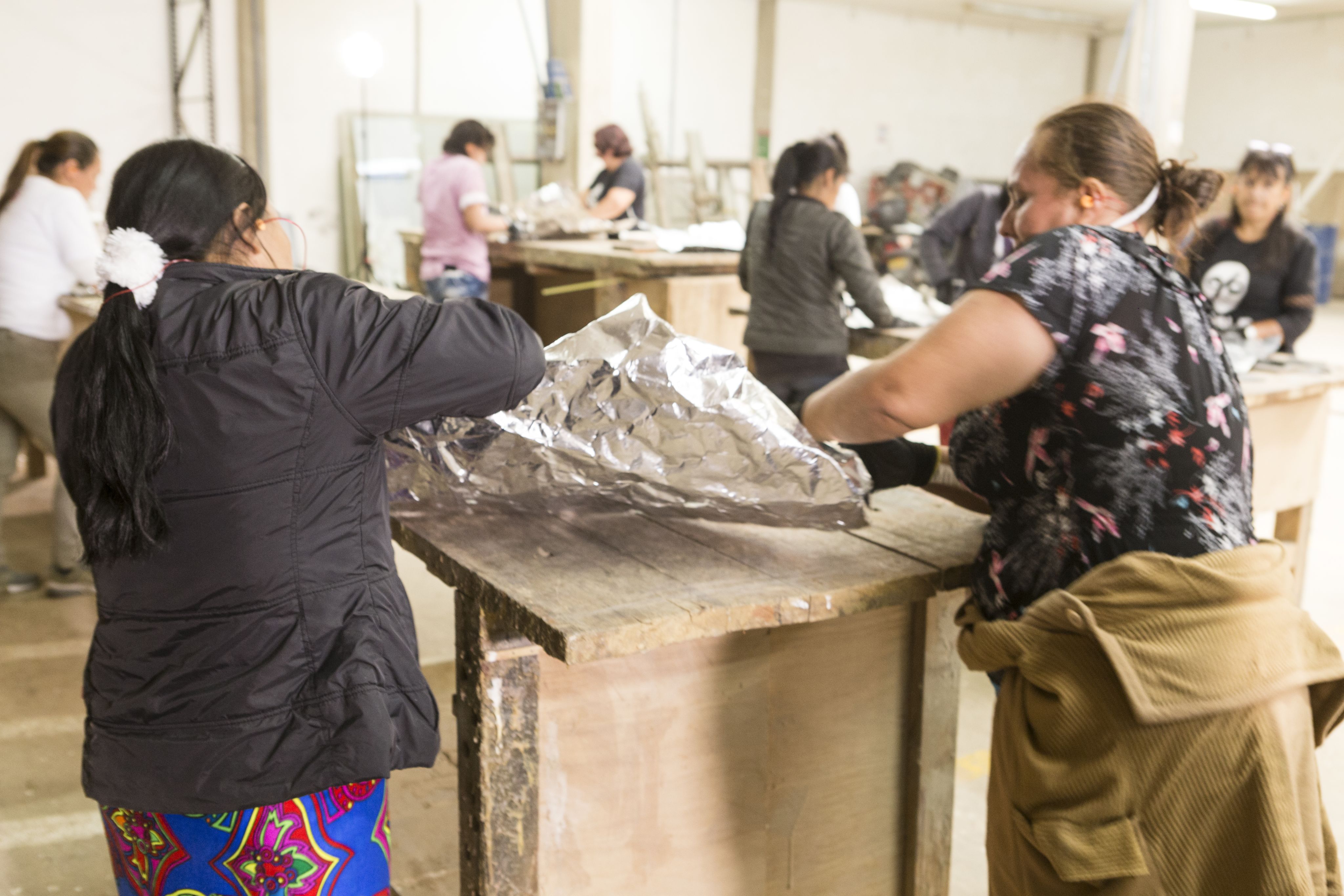 Two woman working on a sculpture.