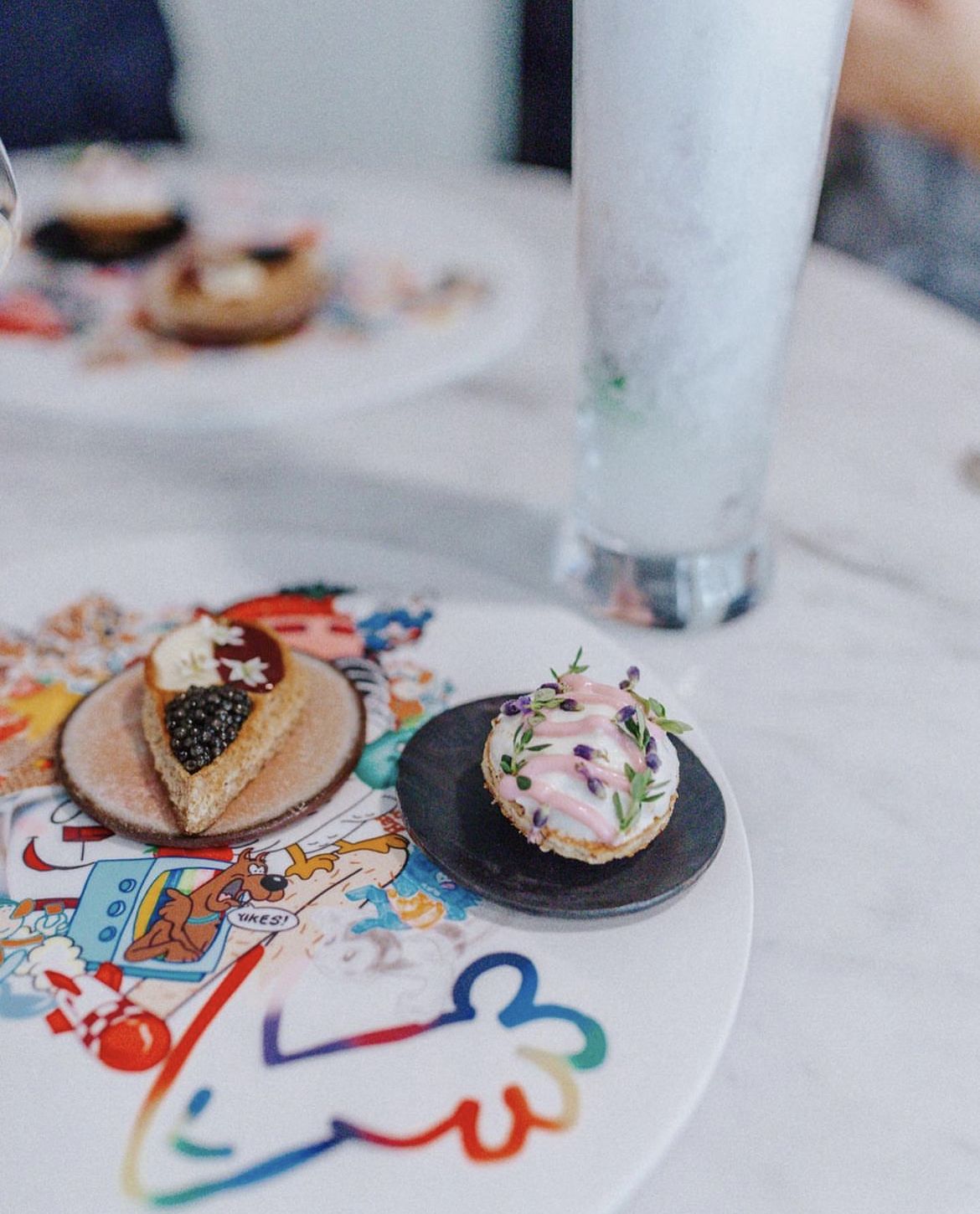 Close up shot of a white marble table with plates of food.