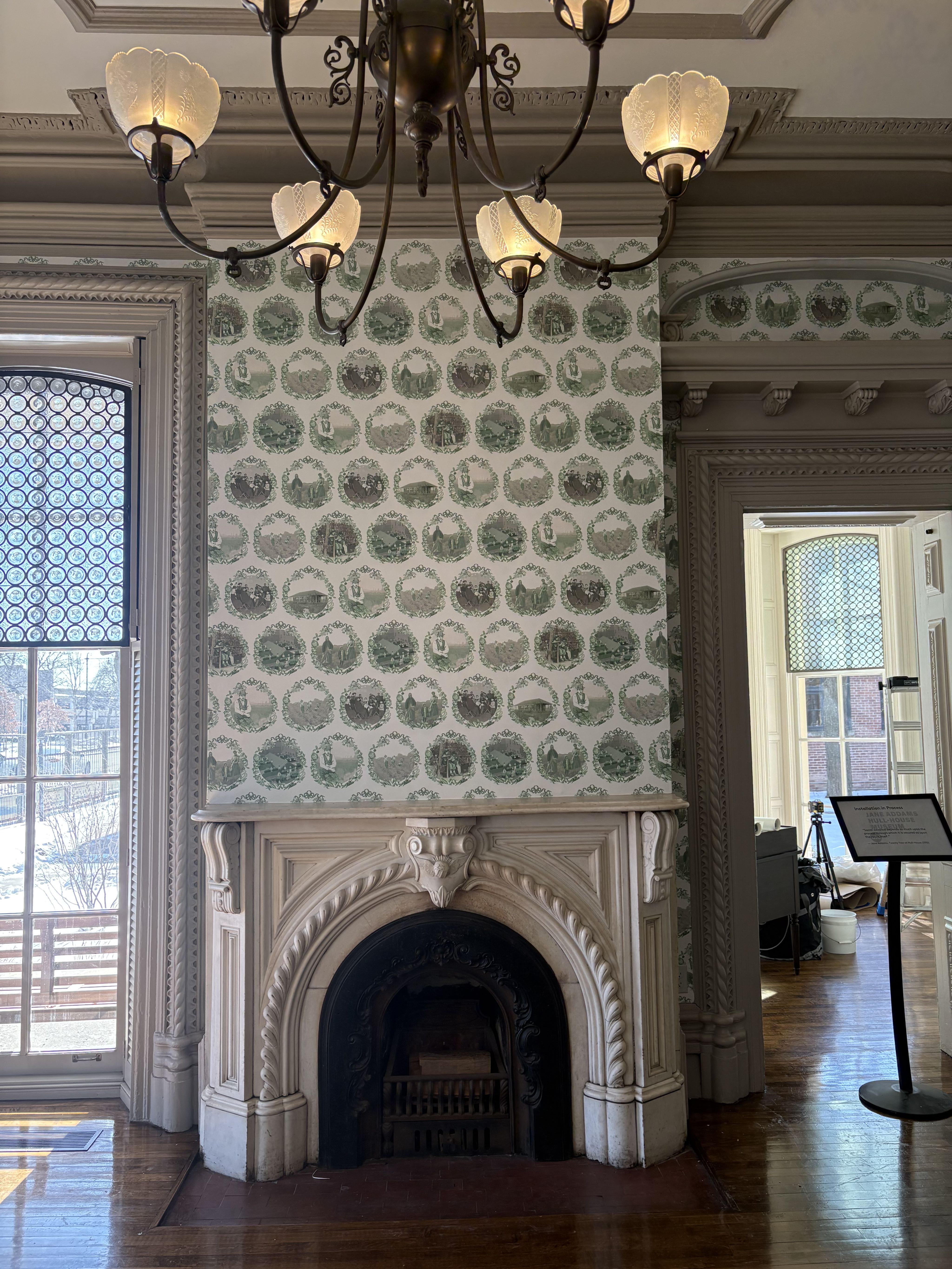 An ornate fireplace with wallpaper installed around it