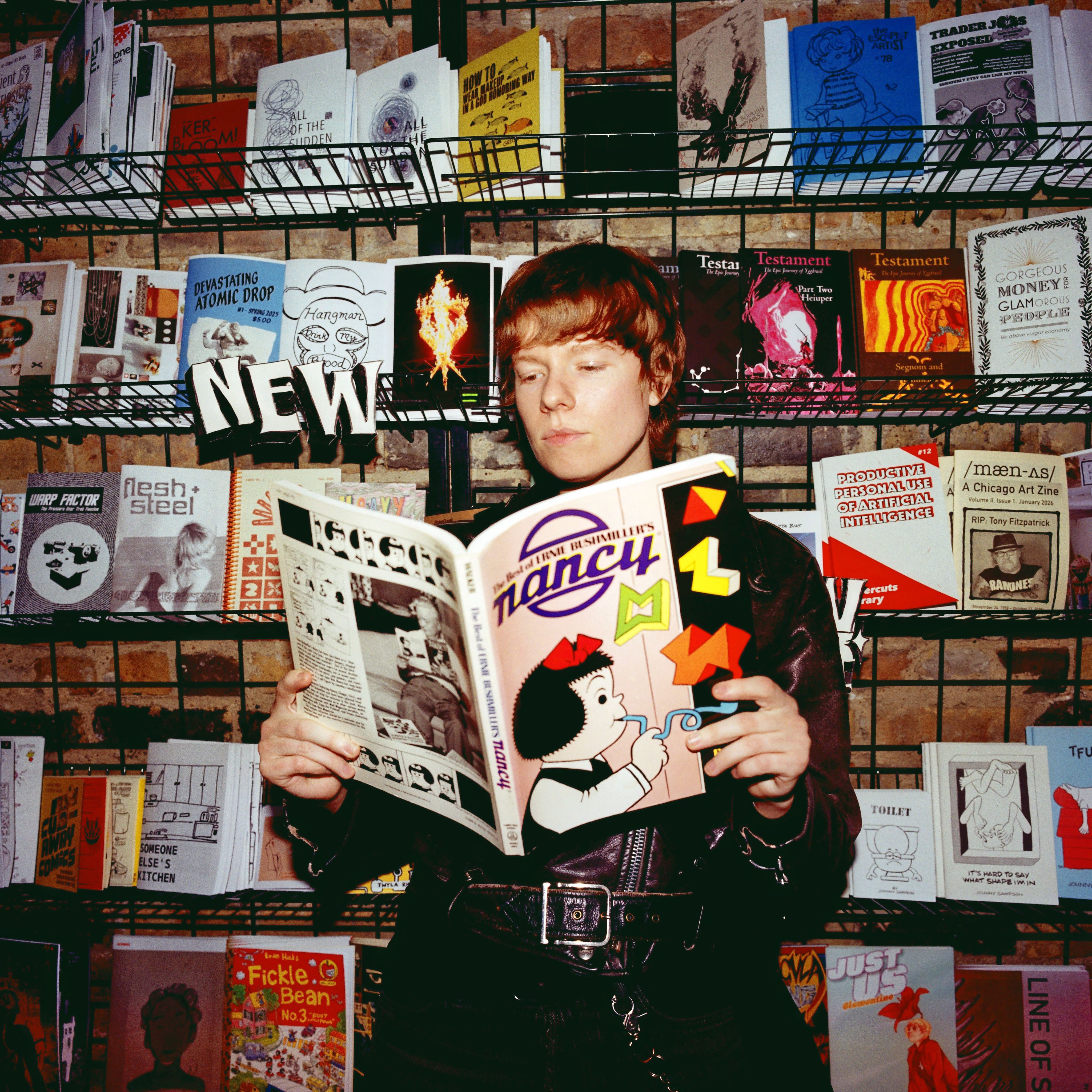 Cash reads a Nancy collection against a Quimby's bookstore shelf
