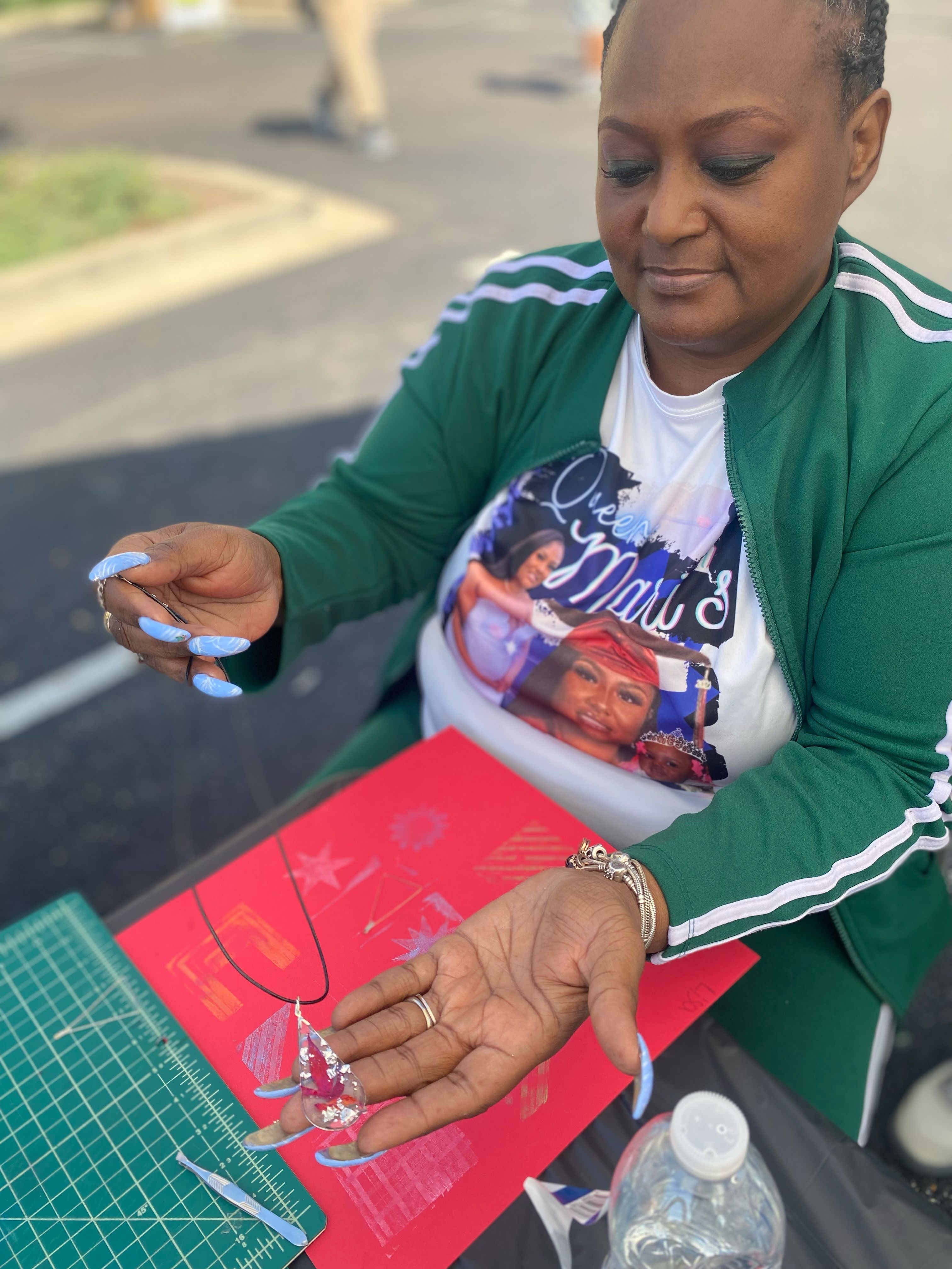 A woman holds up a necklace