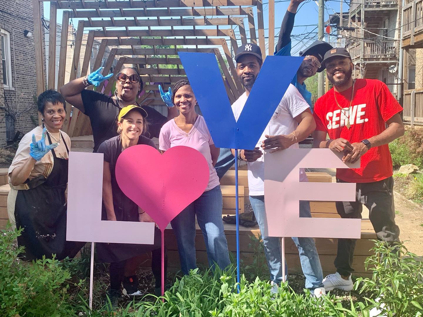 Community members pose by painted metal LOVE signs