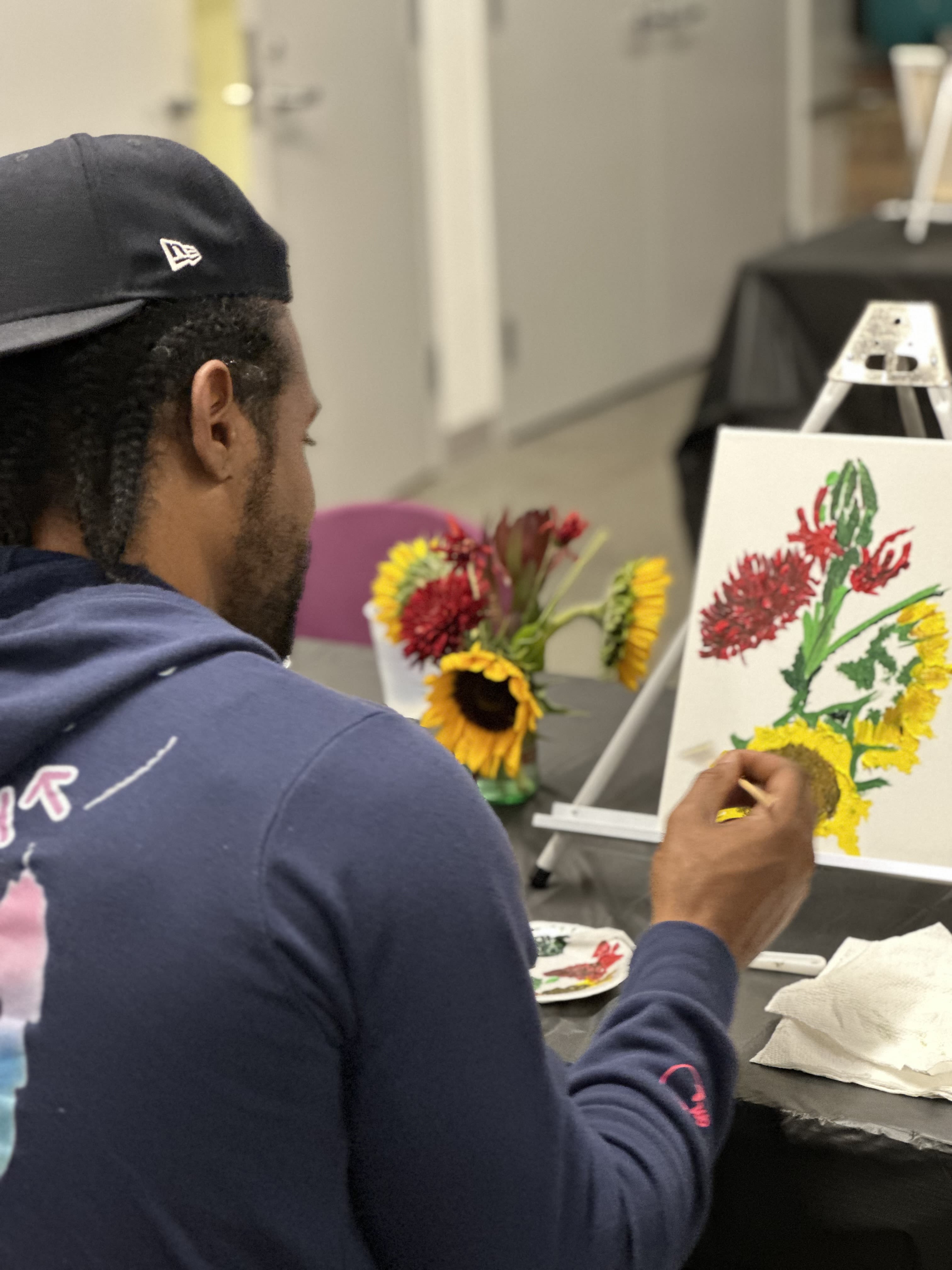 A student paints a floral still life