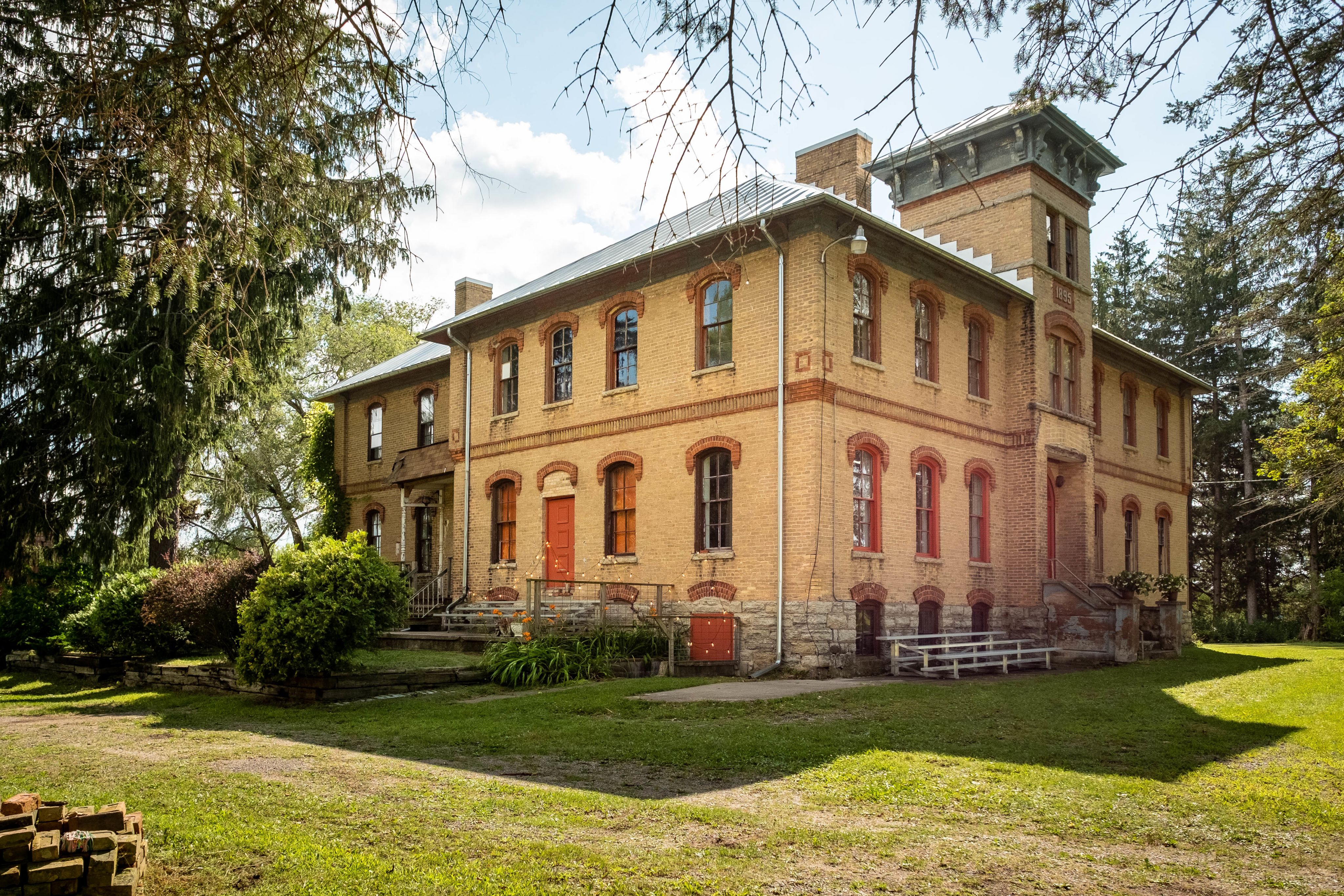 The exterior of a brick building surrounded by trees