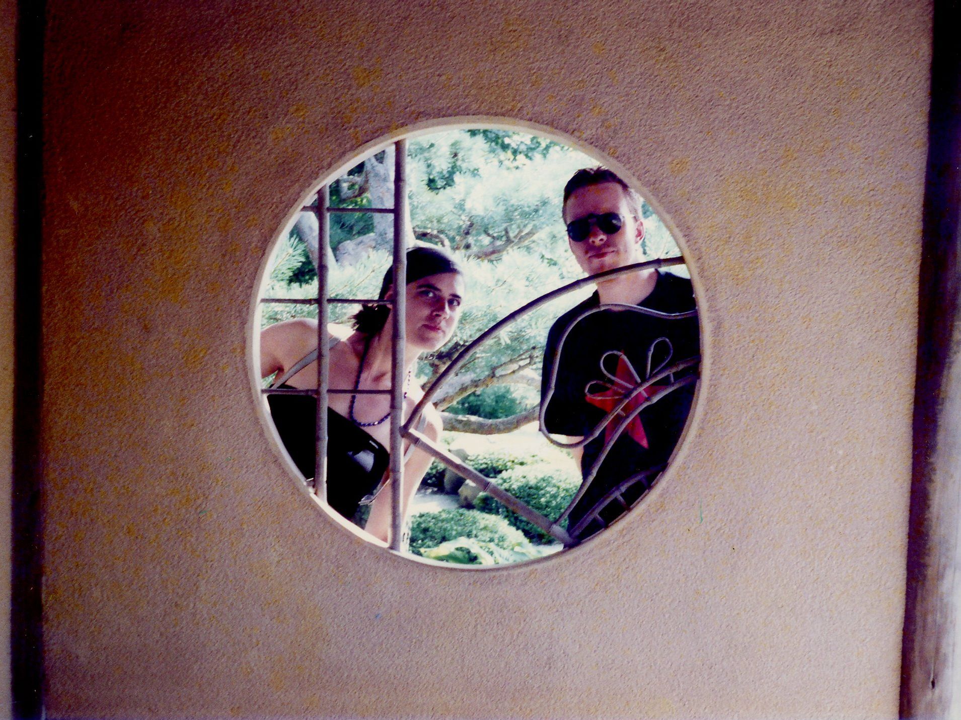 A couple looks out through a circular window