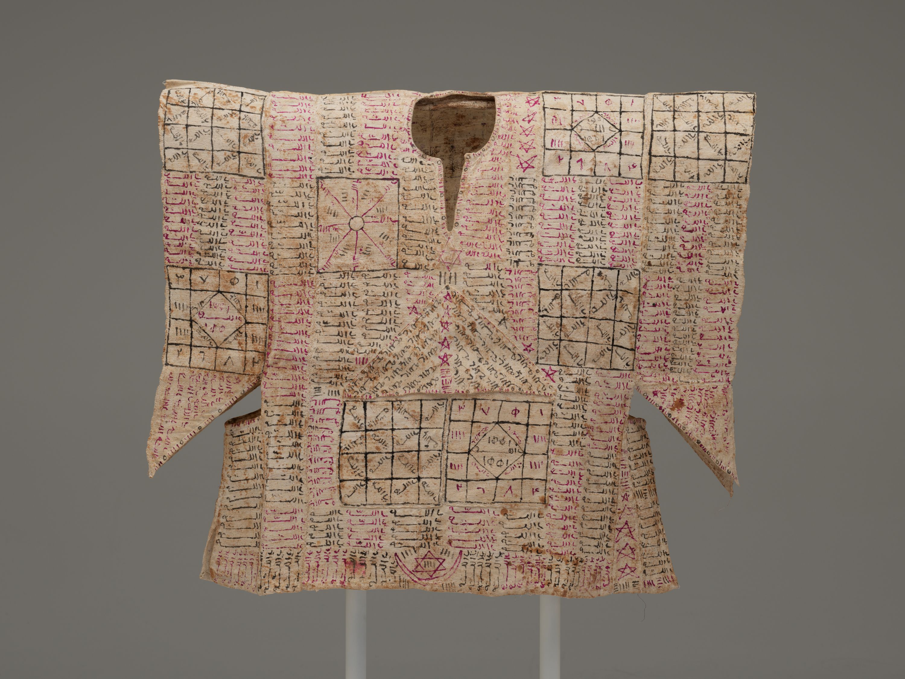 A tunic embroidered with red and black symbols.