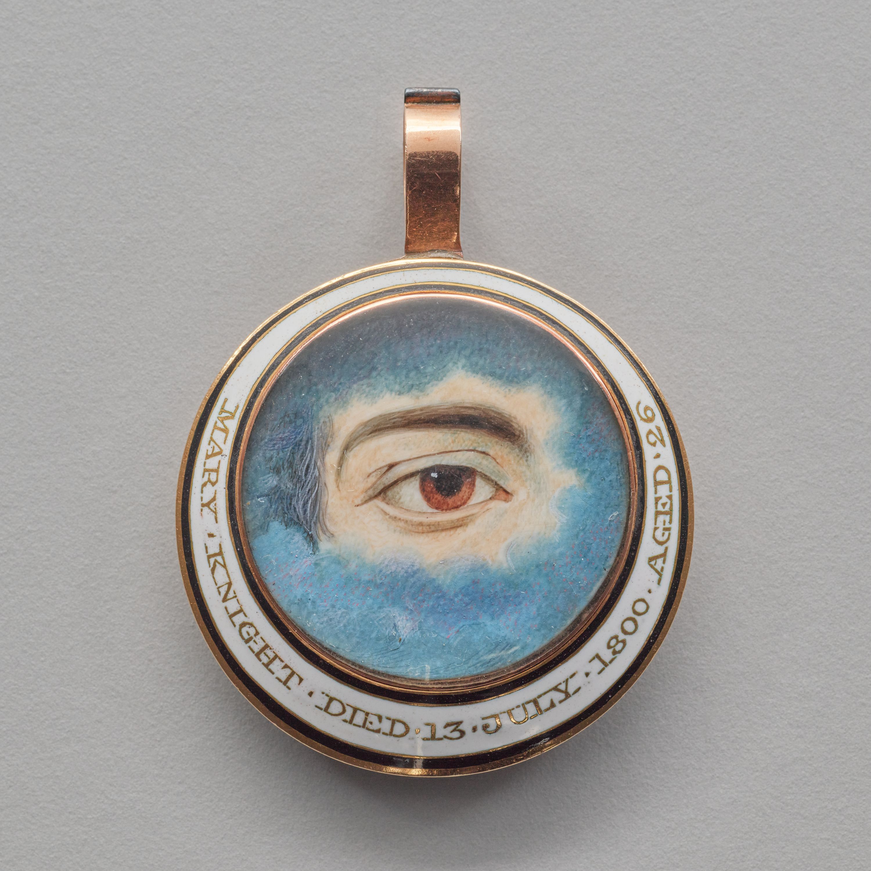 A memorial pendant painted with a brown eye 